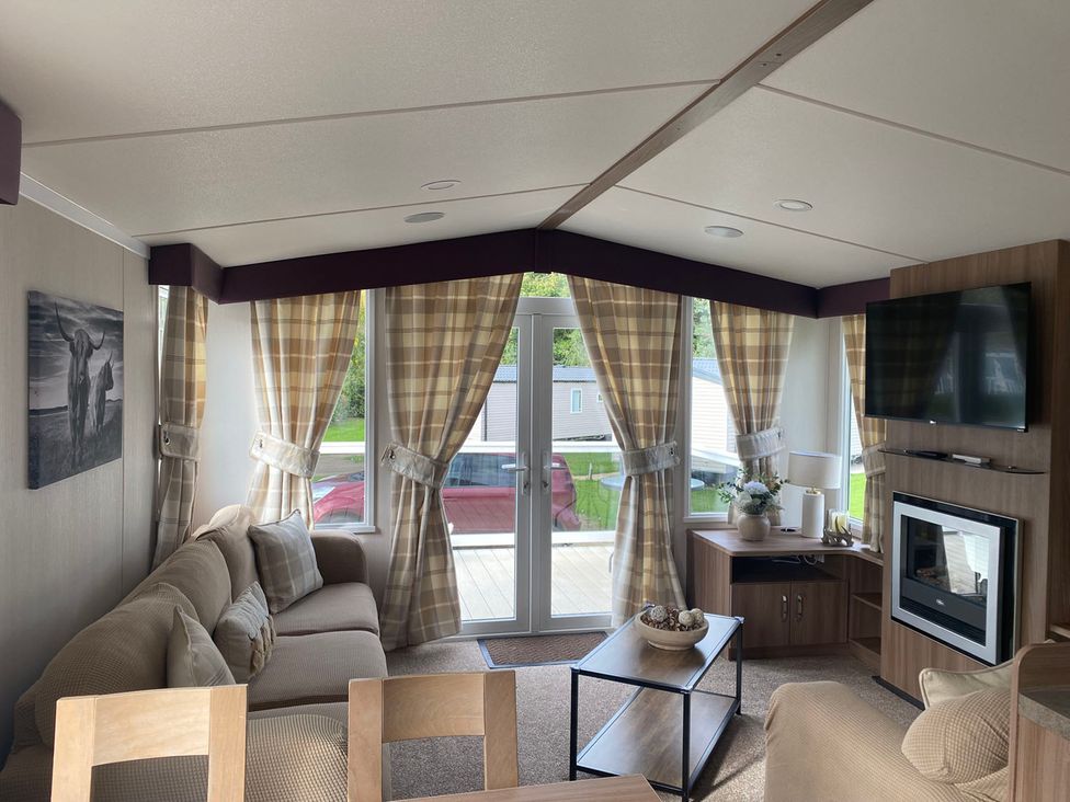 A living room with a sofa, coffee table, and television at the property in an unknown location