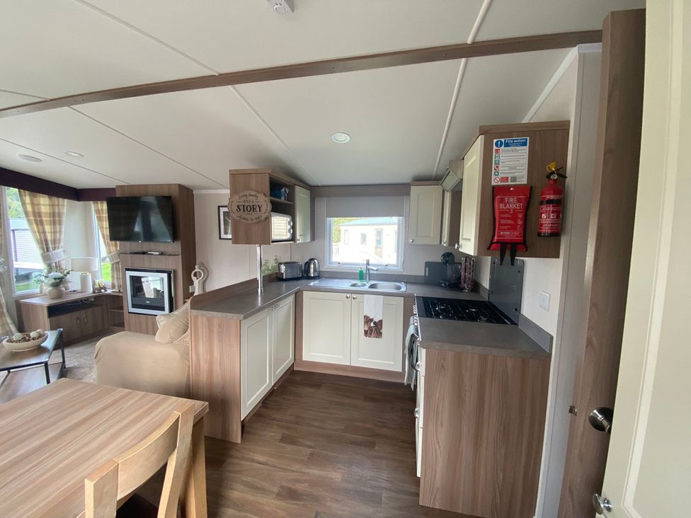 A kitchen with dining table and seating at The Holiday Home in Unknown