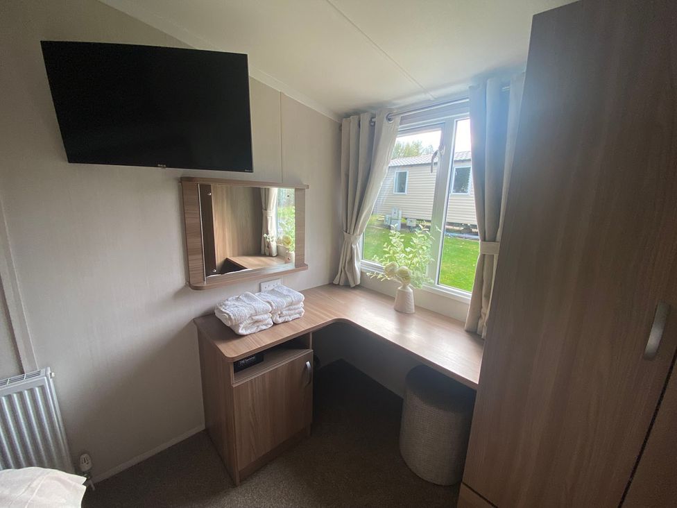 A bedroom with a desk and mirror at the property in location