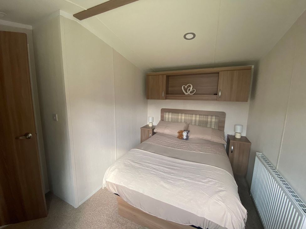 A bedroom with a bed and bedside tables at 