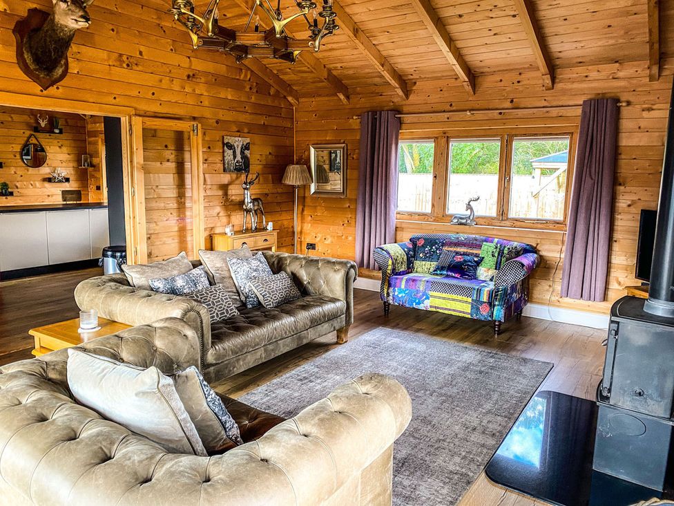 A living room with a sofa and armchair at The Cabin in The Woods
