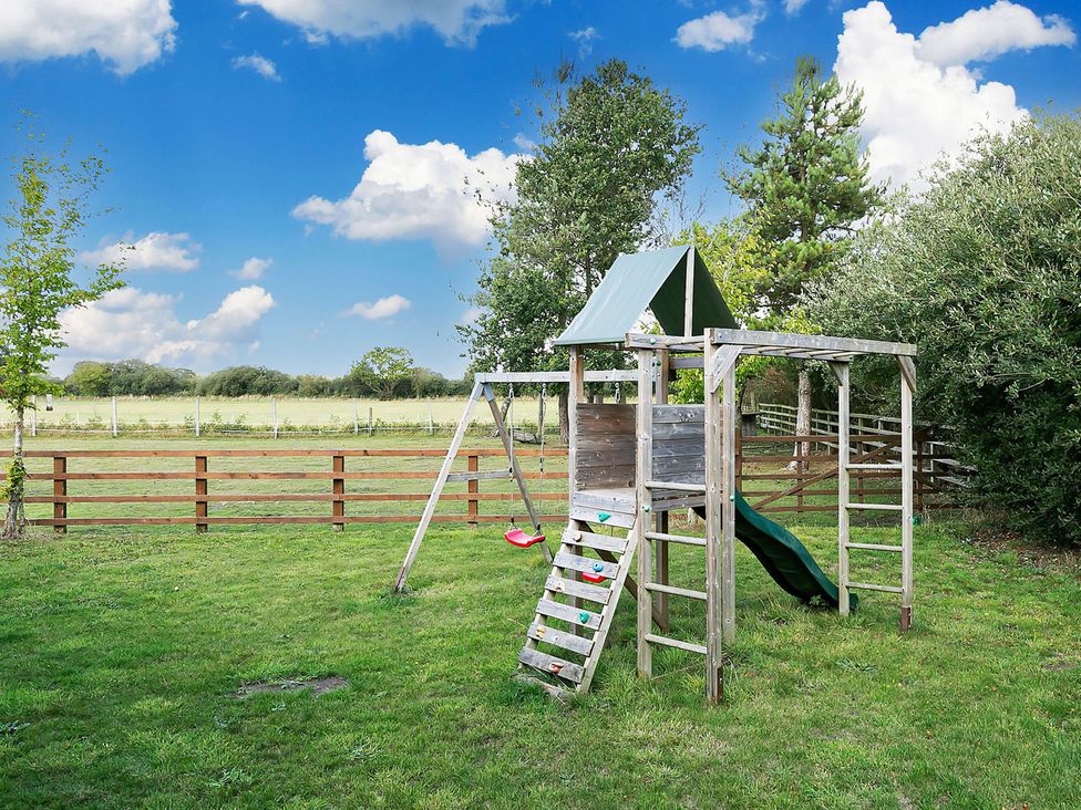 A playground with a slide and swing set in a grassy area