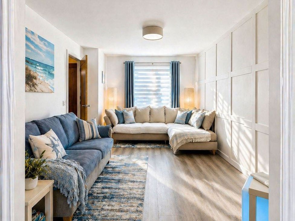 A living room with a sectional couch and wall art at The Old Barn in Manchester