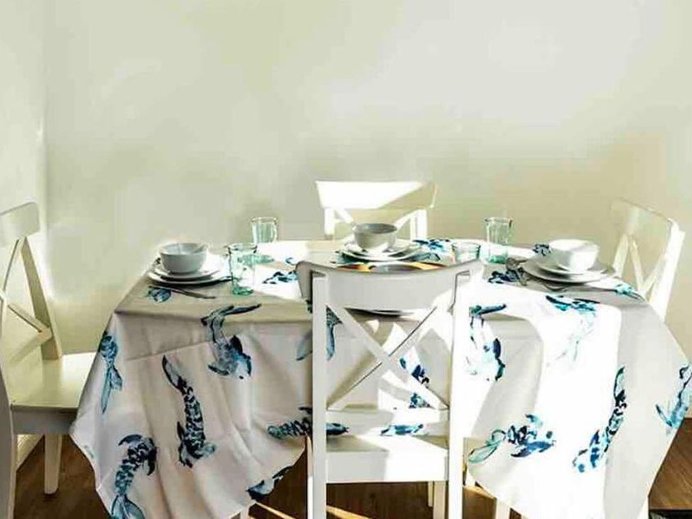 A dining room with a table set for meals at property in unknown location