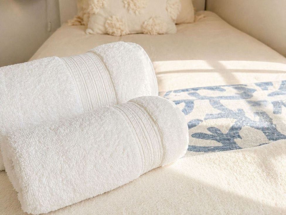 A bed with towels on it at The Old Barn in Manchester
