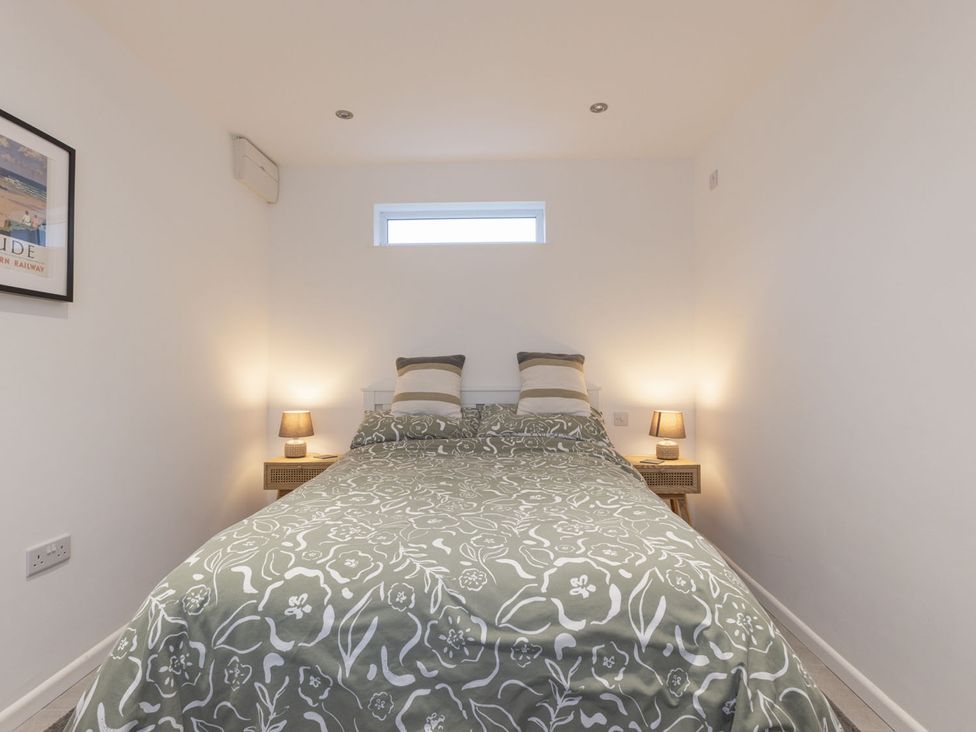 A bedroom with a bed and nightstands at 1Bed Coastal Retreat Sleeps 2 Parking Wifi Bude