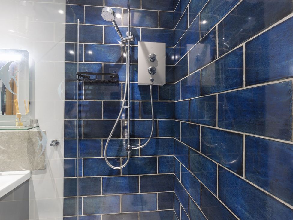A bathroom with blue tiled walls and a shower at 1Bed Coastal Retreat Sleeps 2 Parking Wifi Bude