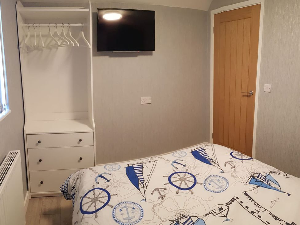 A bedroom with a bed, wardrobe, and television at the property in location