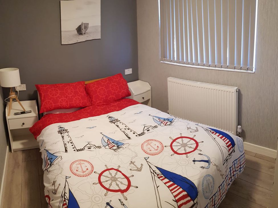 A bedroom with a bed and bedside table at The Old Barn in Manchester