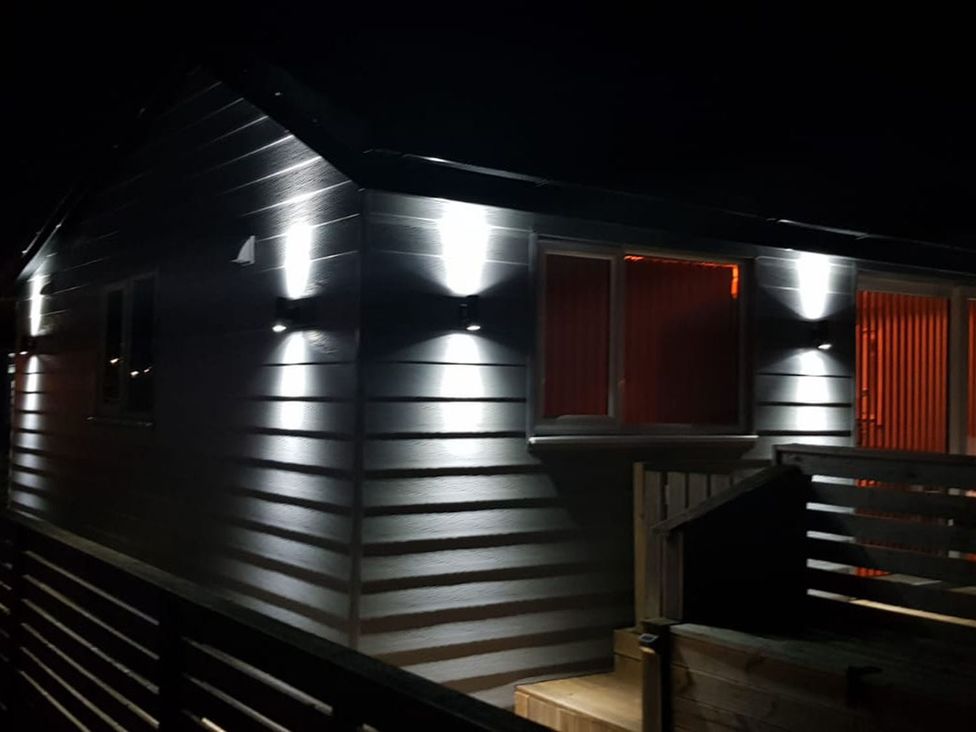 An illuminated exterior of a building with lights and a deck at 