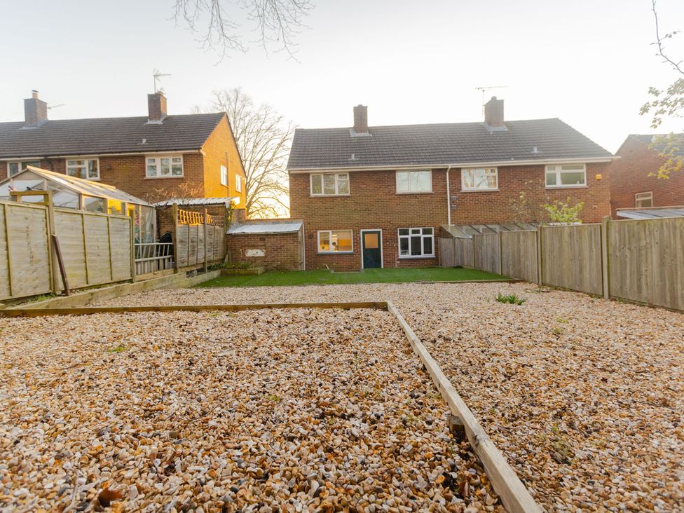 A garden with pebbles and houses in the background at the property