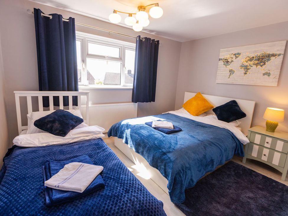 A bedroom with two beds and a map on the wall at The Old Barn in Manchester