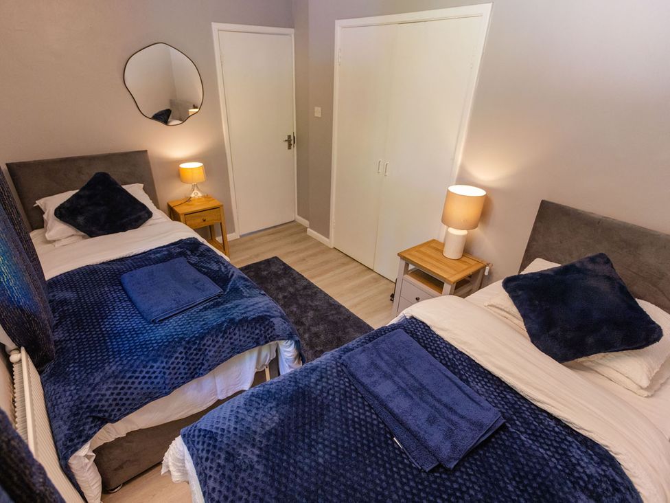 A bedroom with two beds and a nightstand at 