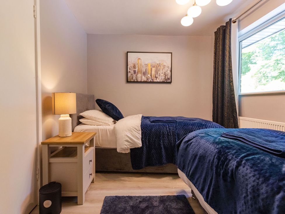 A bedroom with two beds and a nightstand at The Old Barn in Manchester
