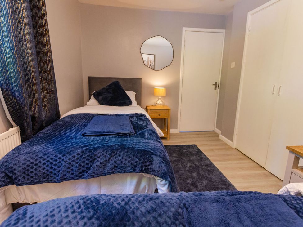 A bedroom with two beds and a nightstand at The Old Barn in Manchester