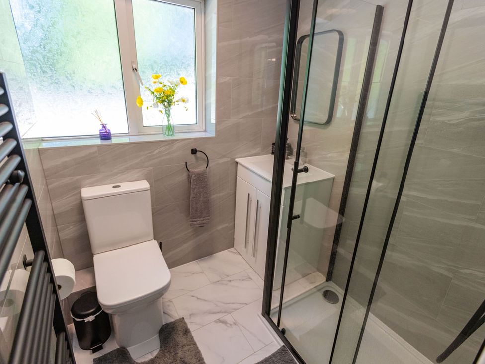 A bathroom with a shower, toilet, and sink at the property in location