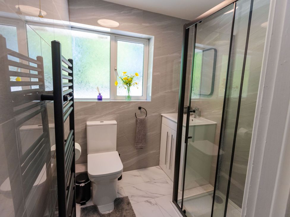 A bathroom with a shower, toilet, and sink at The Old Barn in Manchester