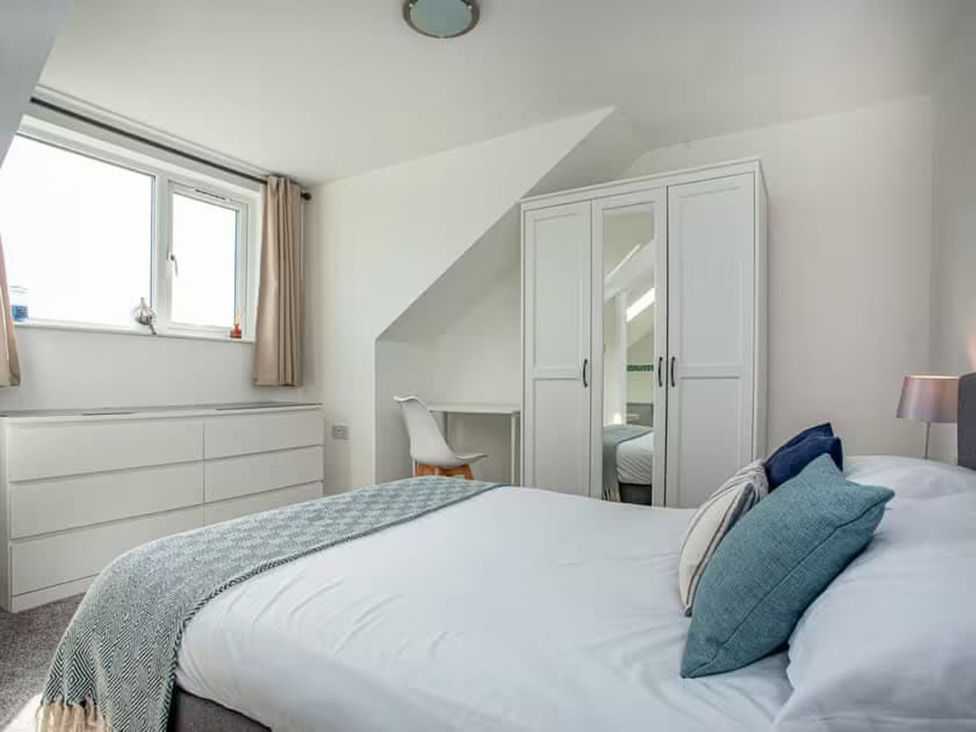 A bedroom with a bed and wardrobe at Spacious 3 Bed House Sleeps 6 Parking Wifi in Newquay