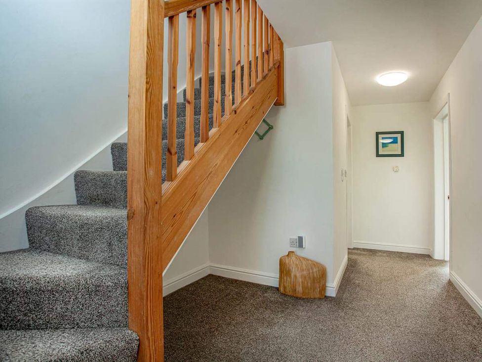 A staircase and hallway with a picture frame at Spacious 3 Bed House Sleeps 6 Parking Wifi Newquay