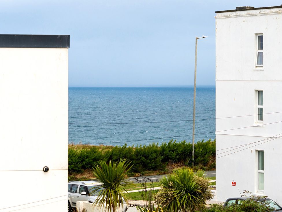 View of the sea between two buildings at Spacious 3 Bed House Sleeps 6 Parking Wifi Newquay