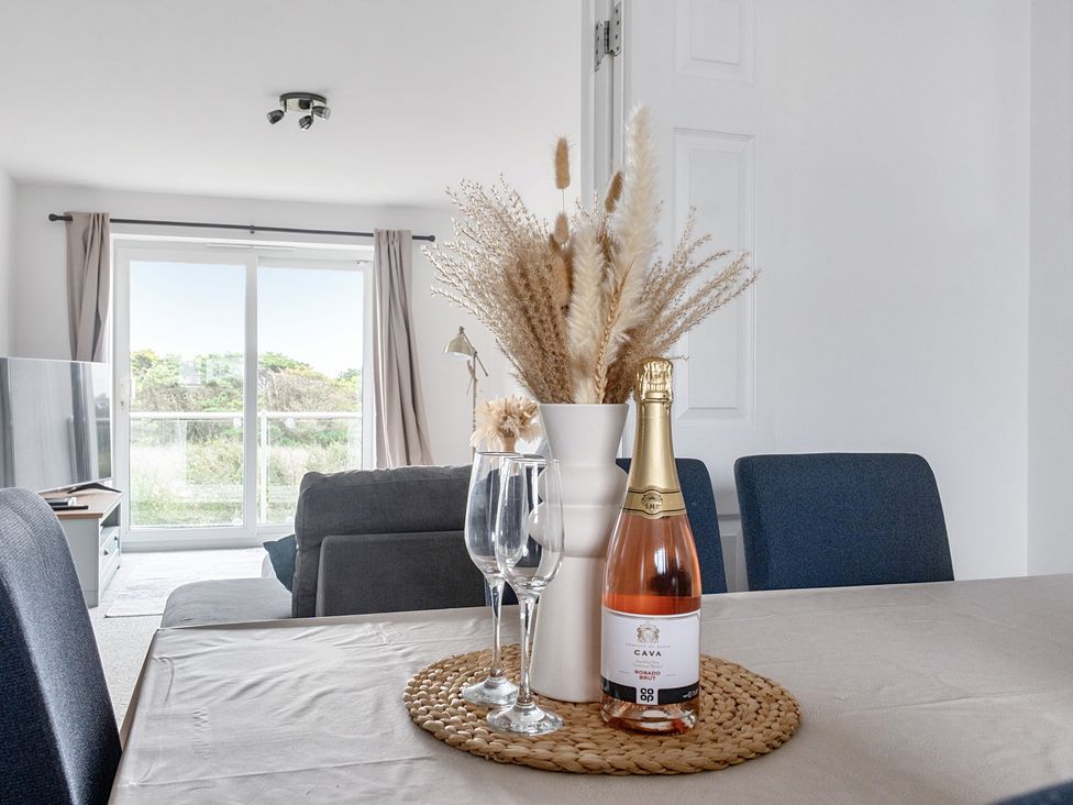 A dining room with a table, glasses, and a vase at Spacious 3 Bed House Sleeps 6 Parking Wifi in Newquay