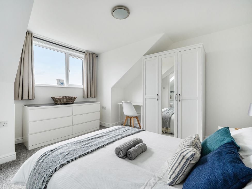 A bedroom with a bed, dresser, and wardrobe at Spacious 3 Bed House Sleeps 6 Parking Wifi in Newquay