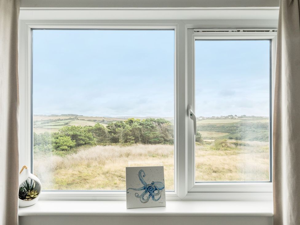 A window with a landscape view and a painting at Spacious 3 Bed House Sleeps 6 Parking Wifi in Newquay