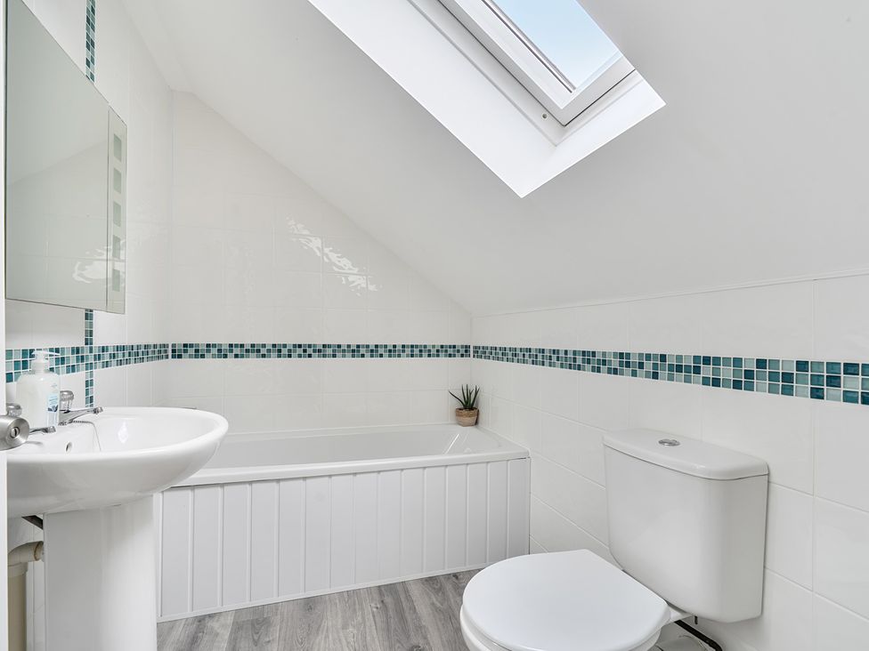 A bathroom with a bathtub, toilet, and sink at Spacious 3 Bed House Sleeps 6 Parking Wifi in Newquay