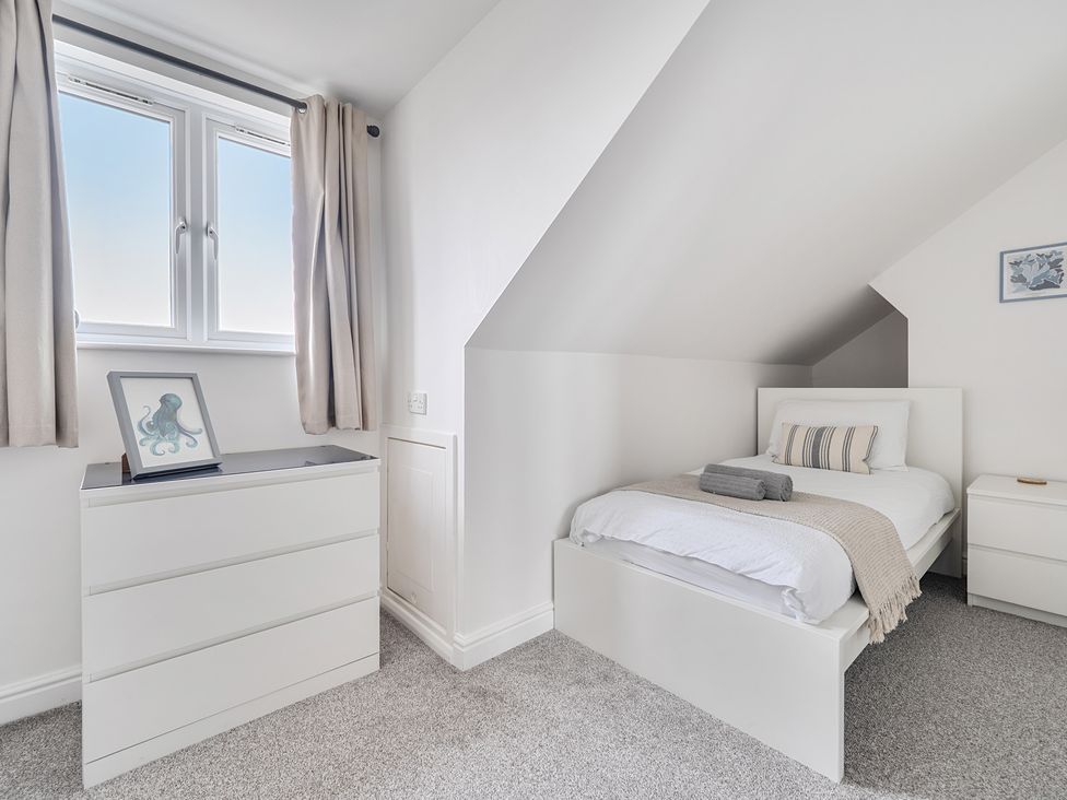 A bedroom with a bed and dresser at Spacious 3 Bed House Sleeps 6 Parking Wifi in Newquay