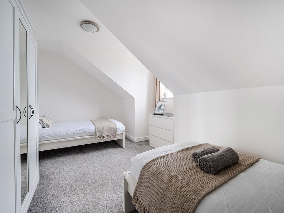 A bedroom with two beds and a wardrobe at Spacious 3 Bed House Sleeps 6 Parking Wifi in Newquay