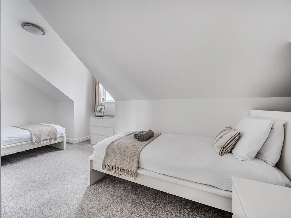 A bedroom with two beds and a nightstand at Spacious 3 Bed House Sleeps 6 Parking Wifi Newquay