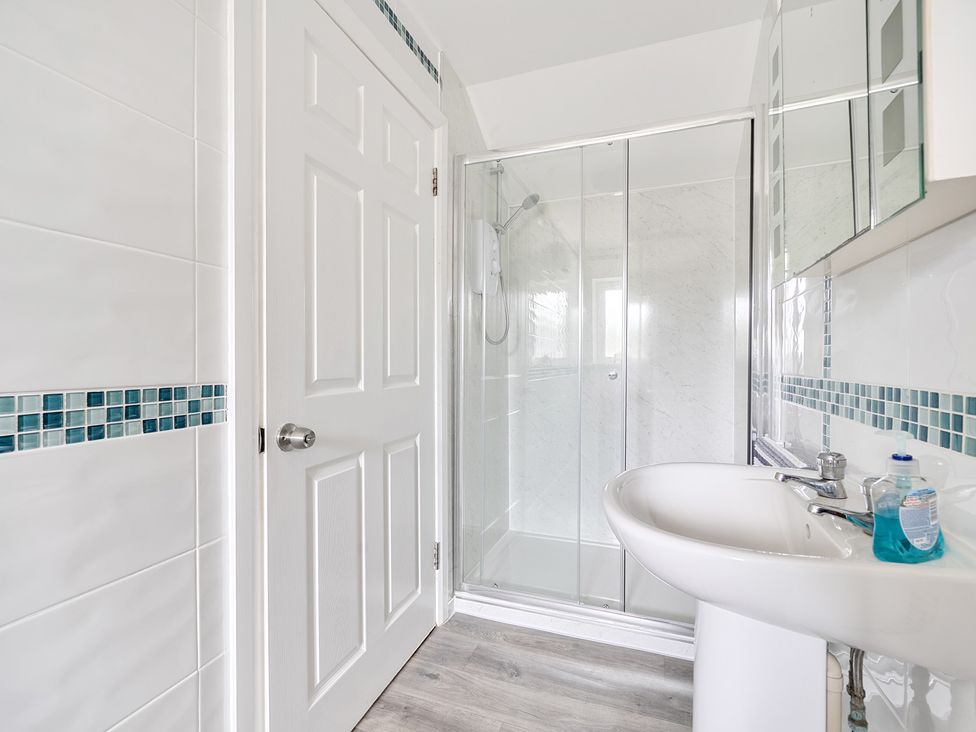 A bathroom with a shower and sink at Spacious 3 Bed House Sleeps 6 Parking Wifi Newquay