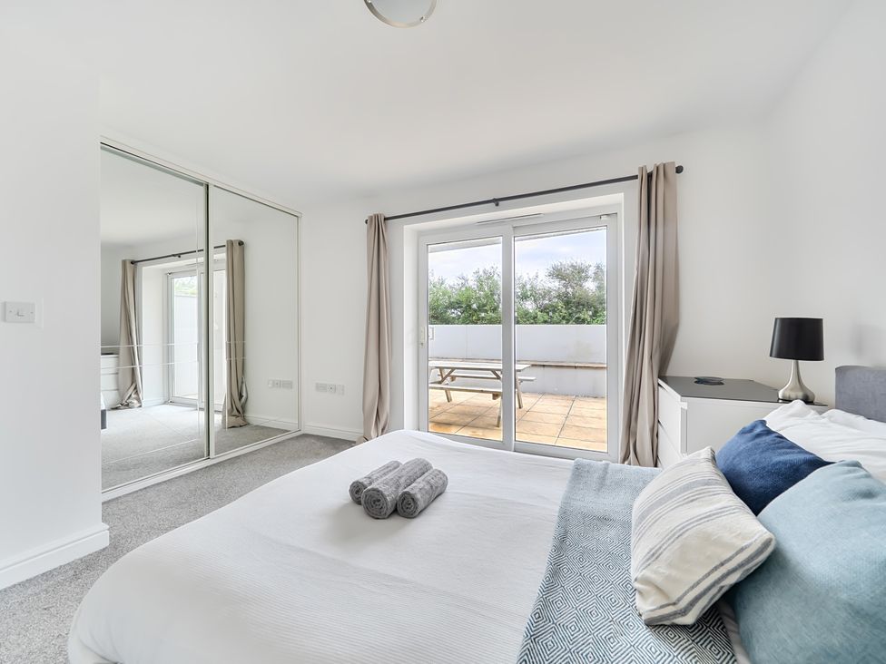 A bedroom with a bed and sliding doors at Spacious 3 Bed House Sleeps 6 Parking Wifi in Newquay