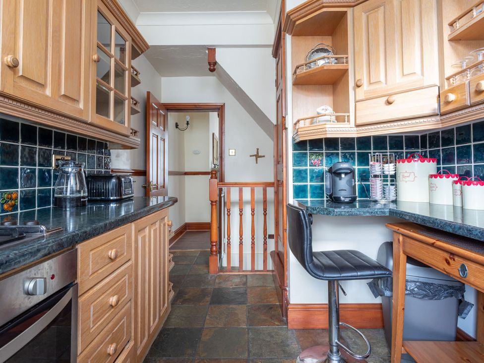 A kitchen with wooden cabinets and a counter at Haworth Village House Sleeps 6 Parking Pets in Cross Roads