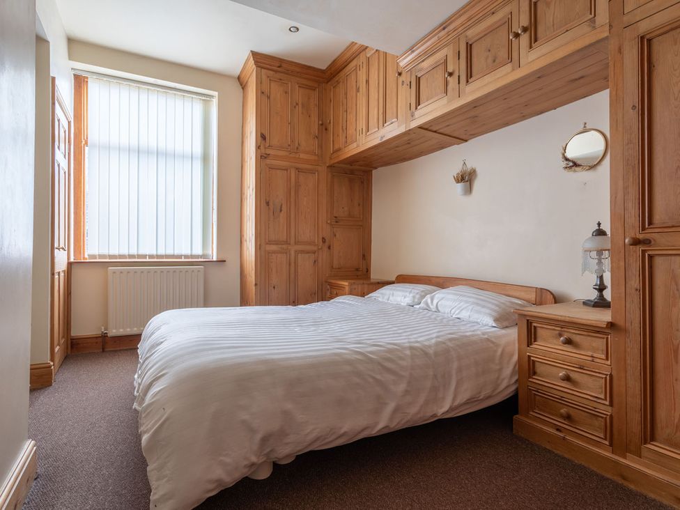 A bedroom with a bed, wardrobe and window at Haworth Village House Sleeps 6 Parking Pets in Cross Roads