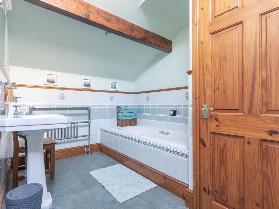 A bathroom with a sink, tub, and radiator at Haworth Village House Sleeps 6 Parking Pets in Cross Roads