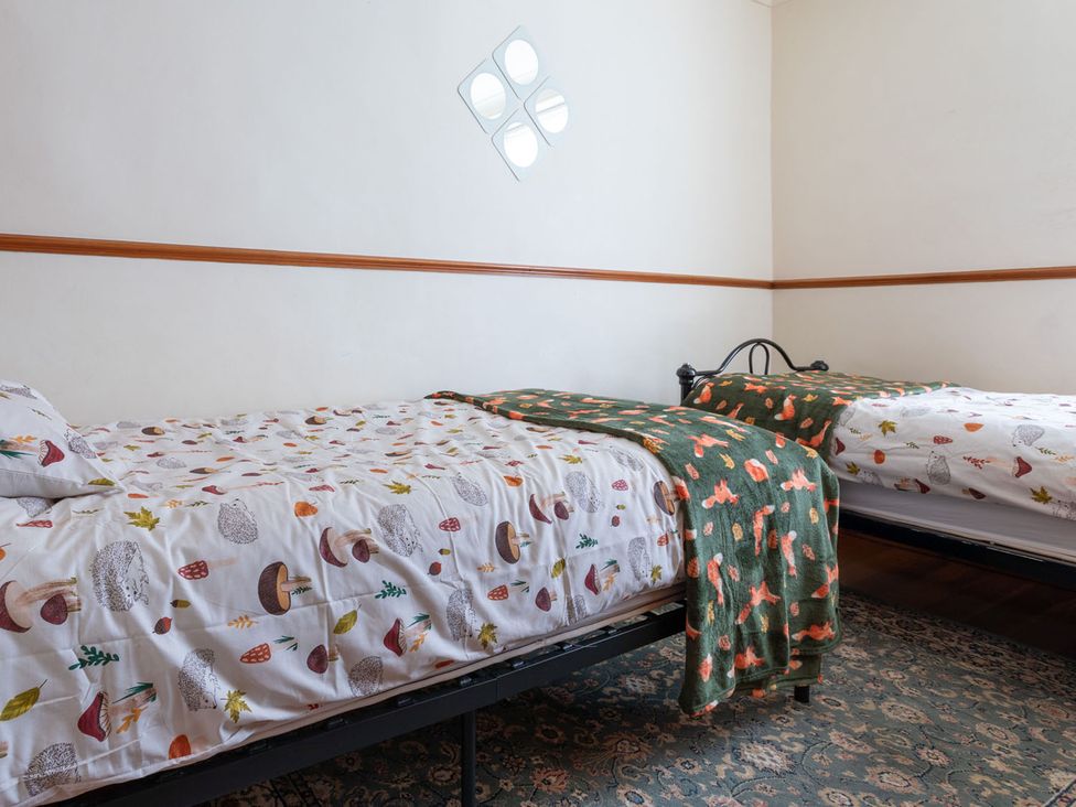 A bedroom with two beds and a rug at Haworth Village House Sleeps 6 Parking Pets in Cross Roads