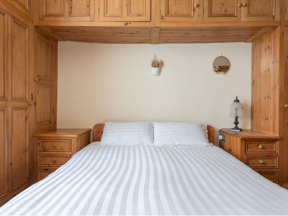 A bedroom with a bed, nightstands, and storage at Haworth Village House Sleeps 6 Parking Pets in Cross Roads