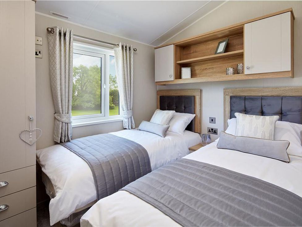A bedroom with two beds and a window at 2Br Lodge Pool Fireplace PetsOK Parking in Goonhavern