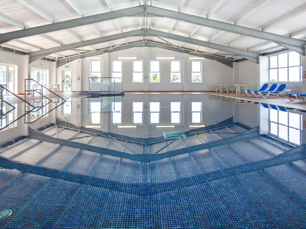 An indoor pool with seating area at 2Br Lodge Pool Fireplace PetsOK Parking in Goonhavern