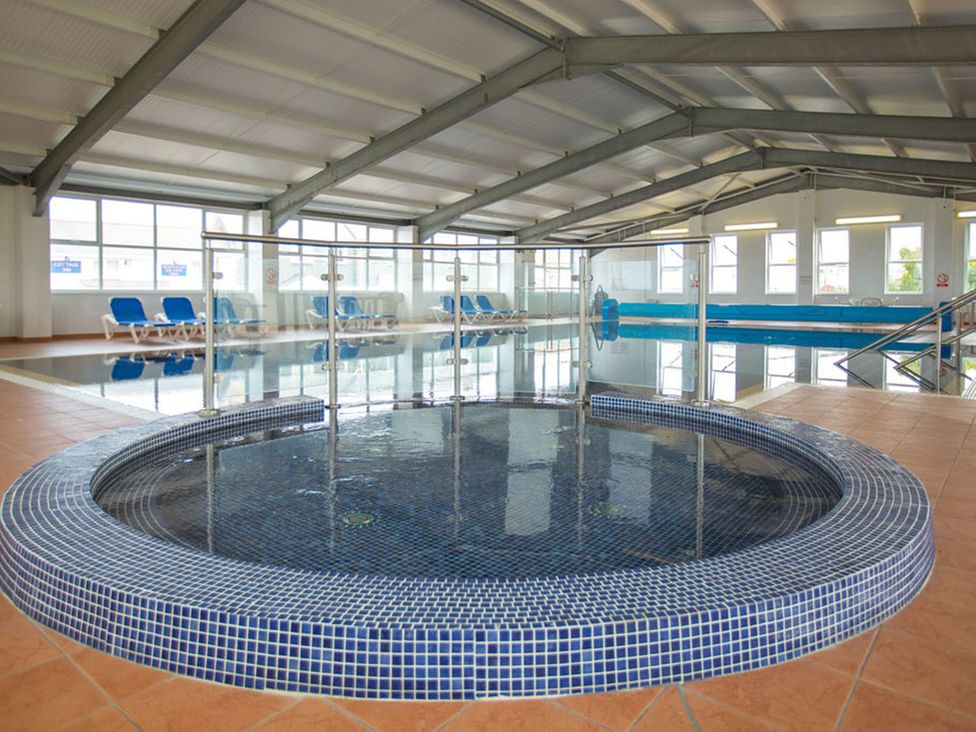 An indoor pool area with a jacuzzi and lounging chairs at 2Br Lodge Pool Fireplace PetsOK Parking Goonhavern