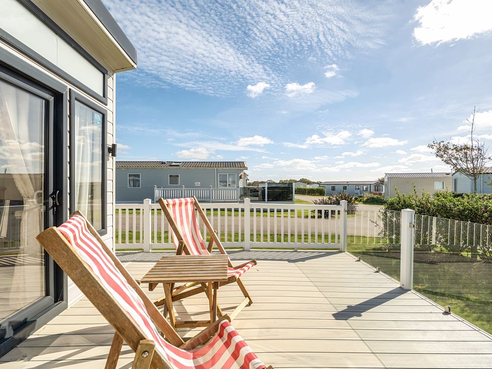 An outdoor patio with chairs and a table at 2Br Lodge Pool Fireplace PetsOK Parking Goonhavern