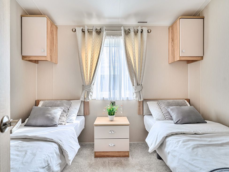 A bedroom with two beds and a plant on a table at 2Br Lodge Pool Fireplace PetsOK Parking Goonhavern
