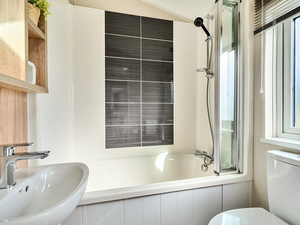 A bathroom with a bathtub, shower, and sink at 2Br Lodge Pool Fireplace PetsOK Parking Goonhavern