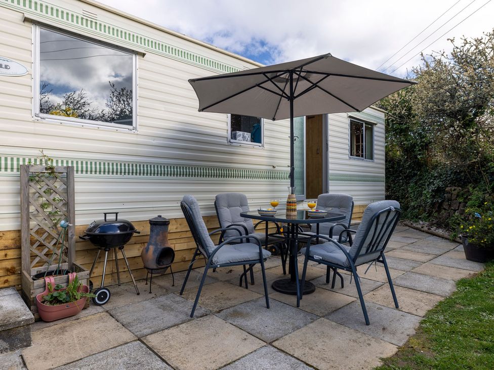 An outdoor patio with table and chairs at Coastal Hideaway in Cornwall Dog Friendly Goldsithney