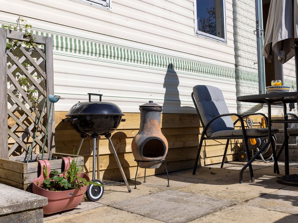 An outdoor area with a barbecue grill and outdoor furniture at Coastal Hideaway in Cornwall Dog Friendly Goldsithney