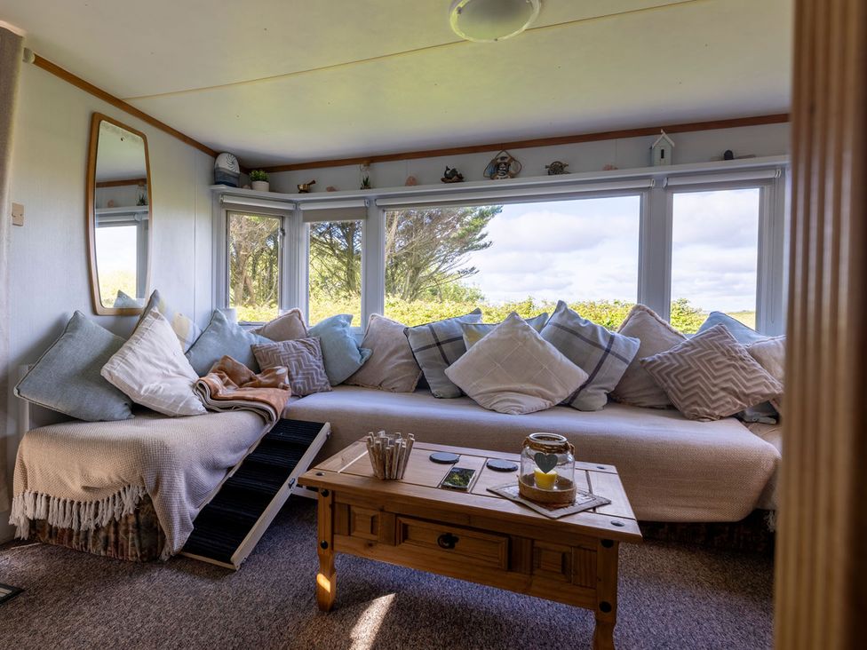 A snug with a sofa and table at Coastal Hideaway in Cornwall Dog Friendly Goldsithney