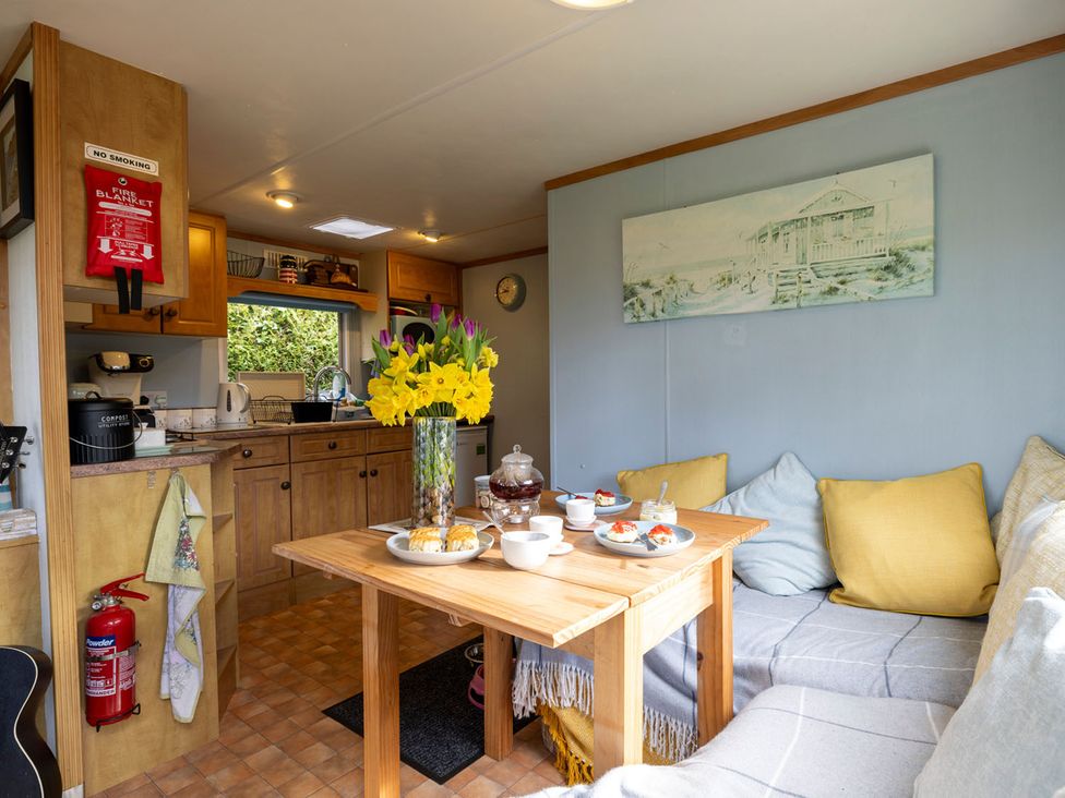 A kitchen with a table and flowers at Coastal Hideaway in Cornwall Dog Friendly Goldsithney