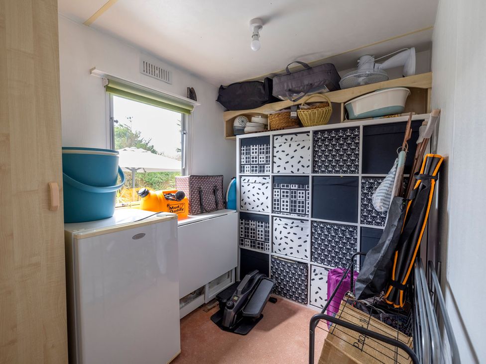 A storage room with shelves and bins at Coastal Hideaway in Cornwall Dog Friendly Goldsithney