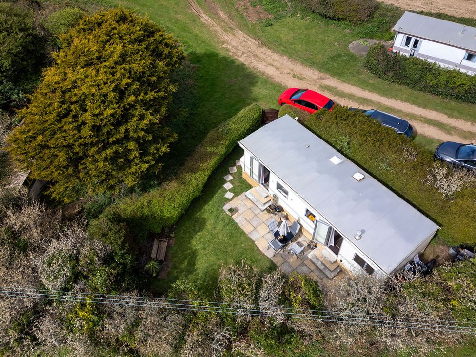An outdoor view of a house with a patio and cars at Coastal Hideaway in Cornwall Dog Friendly Goldsithney